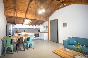 a kitchen and living room with a blue couch and a table at PanoramiKos in Asfendioú