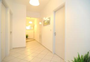 a hallway with white walls and a tile floor at Arolithos in Spetses