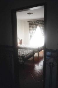 Habitación con cama, ventana y espejo. en River House T2 Tavira Santa Luzia, en Tavira