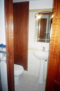 a bathroom with a sink and a toilet and a mirror at River House, T2 Tavira – Santa Luzia in Tavira