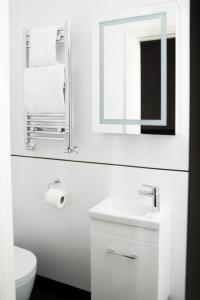 ロンドンにあるHotel 63の洗面台と鏡のある白いバスルーム