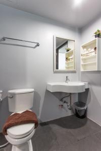a bathroom with a toilet and a sink at The Earth Anthioch Khao Yai in Nakhon Ratchasima