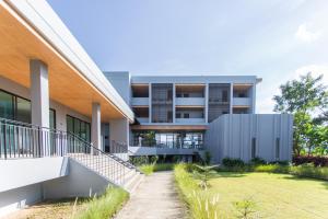 an external view of a building with a lawn at The Earth Anthioch Khao Yai in Nakhon Ratchasima