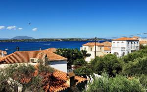a group of buildings on a hill next to the water at Arolithos in Spetses