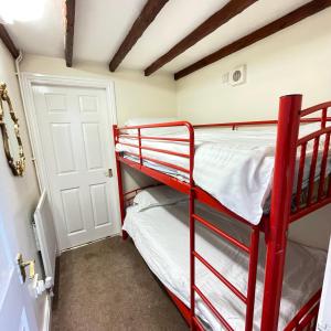 ブリッジノースにあるHalfway House Inn & Cottagesの赤い二段ベッドの部屋(二段ベッド2台付)