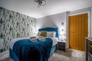 een slaapkamer met een blauw bed en handdoeken bij 12 St. John's Mews in York