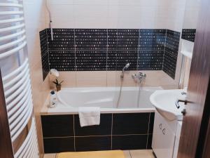 a bathroom with a tub and a sink at Hotel Horse Riding - Jezdecký Areál Tršice in Tršice