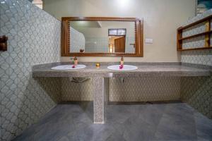 a bathroom with two sinks and a mirror at Meremeta Lodge in Utende