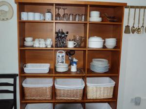 a shelf filled with dishes and plates on top at Kwerky Cottage in North Lydbury +33 photos