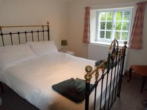 a bedroom with a bed and a window at Kwerky Cottage in North Lydbury