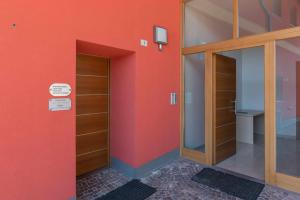 a room with orange walls and wooden shelves at Appartamento al Rio Grauno Ospitar in Grauno