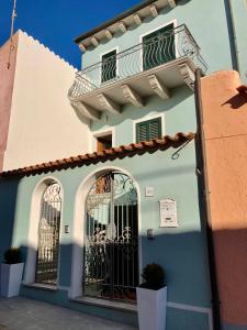 - un bâtiment bleu et blanc avec un balcon dans l'établissement Il Gabbiano case vacanza, à Santa Teresa Gallura