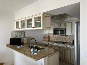 - une cuisine avec des placards blancs et un évier dans l'établissement Sea Oats 312 Condominium Condo, à Boca Grande