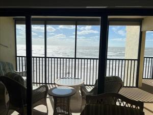 d'un balcon avec une table et des chaises donnant sur l'océan. dans l'établissement Sea Oats 312 Condominium Condo, à Boca Grande