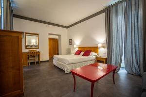 a hotel room with a bed and a red table at Hotel del Real Orto Botanico in Naples +89 photos