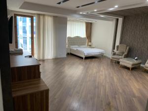 - une chambre avec un lit, un canapé et une chaise dans l'établissement Park Azure Apartment Deluxe 2 Bedroom, à Baku