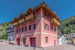 un edificio rosa con balcones encima en Appartamento alla Preda Grauno Ospitar, en Grauno