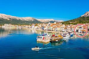 a boat in a body of water next to a town at Apartment Sara in Baška