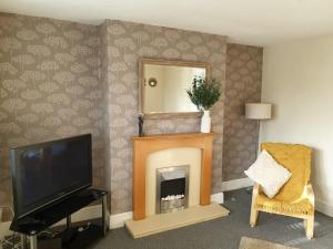 a living room with a fireplace and a television at Flat 1. Cleethorpes apts in Cleethorpes