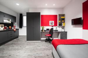 Habitación con escritorio y pared de acento rojo. en Yugo Explore - Arran House, en Edimburgo