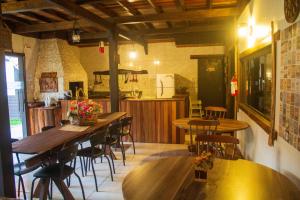a restaurant with tables and chairs and a kitchen at Pousada Caliandra Da Serra in Canela