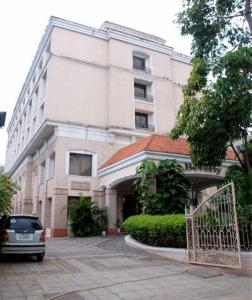 a building with a car parked in front of it at Beverly Hotel in Chennai