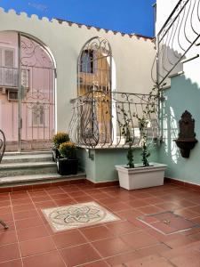une cour d'une maison avec un escalier et des plantes en pot dans l'établissement Il Gabbiano case vacanza, à Santa Teresa Gallura