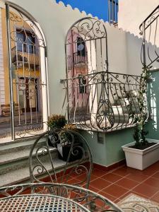 un banc assis devant un bâtiment avec des portes dans l'établissement Il Gabbiano case vacanza, à Santa Teresa Gallura