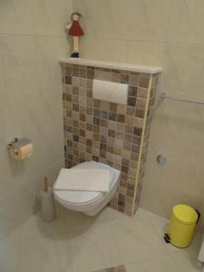 a bathroom with a toilet and a tiled wall at Rooms Stella in Split