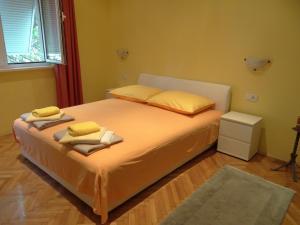 um quarto com uma cama com lençóis amarelos e almofadas amarelas em Rooms Stella em Split