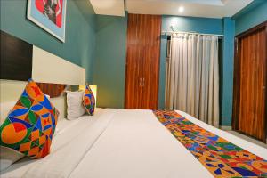 a bedroom with a large bed with blue walls at FabHotel Maxx Inn in New Delhi