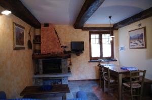 ein Wohnzimmer mit einem Tisch und einem Kamin in der Unterkunft Erebia Appartamenti Vacanza in Villadossola