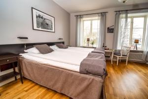 a large bed in a bedroom with a table and chairs at Hotell Slitebaden in Slite
