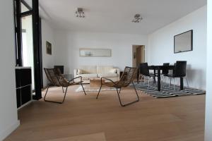 a living room with chairs and a table and a couch at Le Normandy in Pourville-sur-Mer
