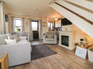 a living room with a couch and a fireplace at Barn Cottage in Bude