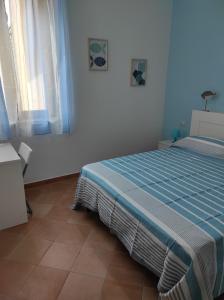 1 dormitorio con 1 cama en una habitación blanca en Kalea Casa Vacanze en Favignana