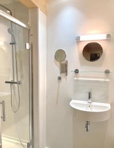 een witte badkamer met een wastafel en een douche bij The Garden Room Apartment in Cardigan