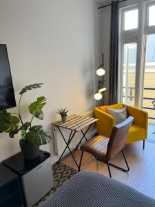 a living room with a yellow couch and a table at Modern Hideout Ace Location in Amsterdam