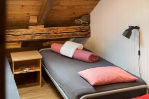 małe łóżko z 2 poduszkami w pokoju w obiekcie Balmers Hostel w mieście Interlaken