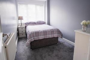 a small bedroom with a bed and a window at Tallets Apartment with Balcony & Parking in Tewkesbury