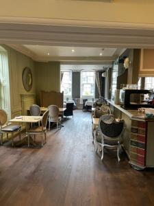 a living room with chairs and tables and a kitchen at The Spread Eagle Hotel in Thame