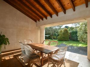 una mesa de madera y sillas en un patio en Cómoda y acogedora casa en precioso entorno, en San Miguel de Meruelo