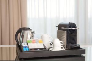 a tray with a coffee maker and cups on a table at NH Collection Villa de Bilbao in Bilbao