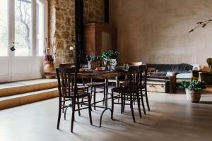 uma sala de jantar com uma mesa de madeira e cadeiras em La pagliera em Agrigento