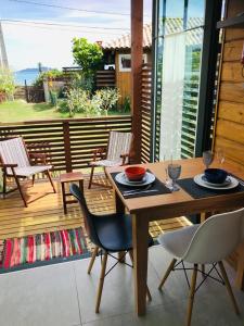 a table and chairs on a patio with a view of the ocean at Bangalôs Floripa - Tiny House in Florianópolis