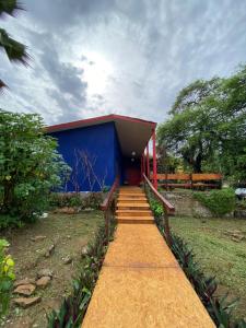 a blue building with a pathway leading to it at La em casa Noronha in Fernando de Noronha