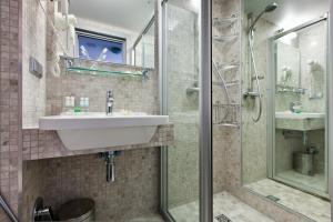 y baño con lavabo y ducha. en Hotel Yalta Intourist, en Yalta
