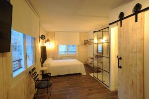 1 dormitorio con cama blanca y ventana en Lombera Apartamentos, en Arnedillo