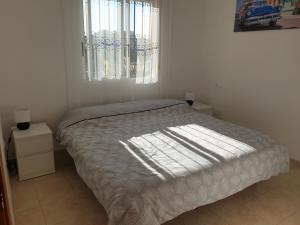 um quarto com uma cama e uma janela com luz solar em Sunlight Apartment - Molino Blanco - La Zenia em Playas de Orihuela