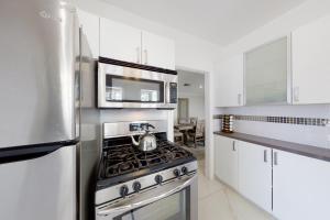 a kitchen with a stove and a microwave at Beverly Hills Central Old World Charm in Los Angeles